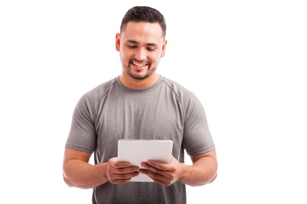 Portrait of a fit gym instructor using a tablet computer to select the right routine for a client