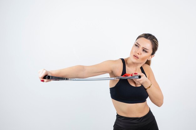 Portrait of fit woman training with gym tool.