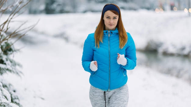 Portrait of fit young woman running in winter