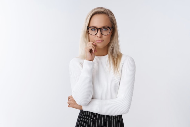 Free photo portrait of focused and serious-looking female entrepreneur working thinking about interesting and risky offer touching lip and looking determined at camera, making decision over white background.