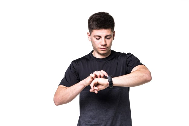 Portrait of a focused young sportsman adjusting his wristwatch isolated over white 
