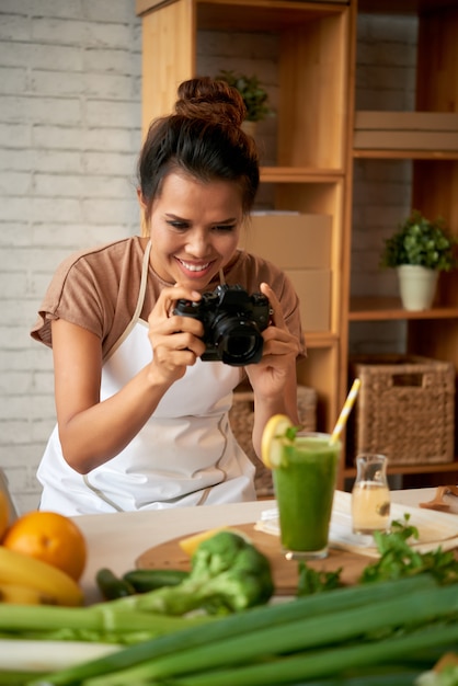 Портрет пищевого блоггера, делающего снимок смузи