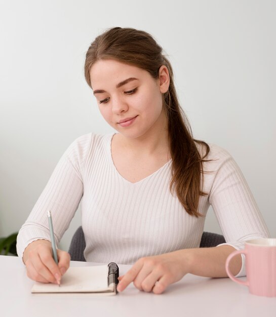 Portrait freelance woman writing in agenda