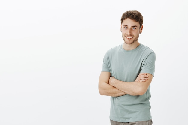 Portrait of friendly excited handsome man with fair hair and earrings