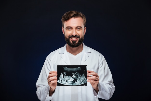 Foto gratuita il ritratto di un medico maschio amichevole si è vestito in uniforme