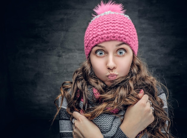 Portrait of funny girl in winter hat with wonder on her face.