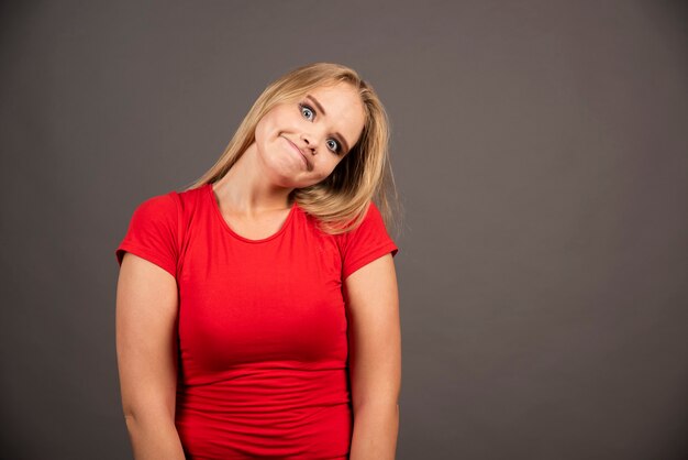 Portrait of funny woman posing over dark.