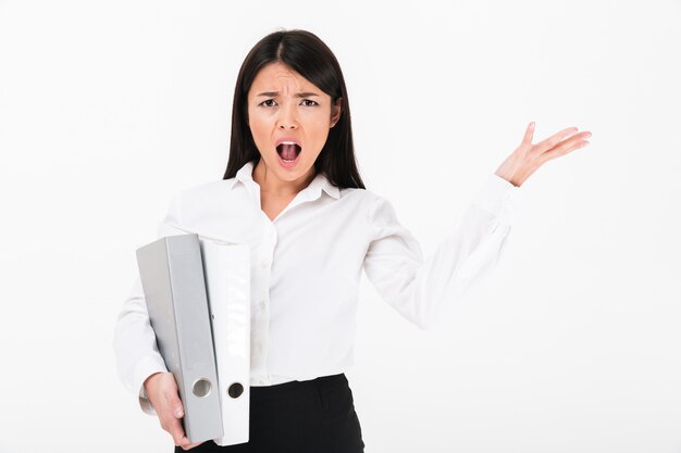 Portrait of a furious asian businesswoman holding binders