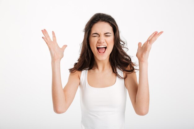 Portrait of a furious girl dressed in tank-top screaming