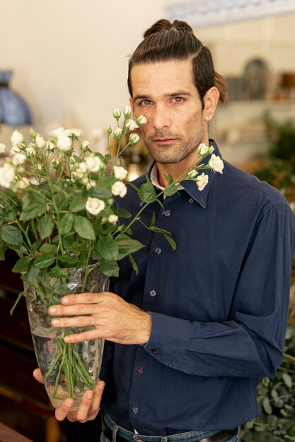 꽃을 들고 긴 머리를 가진 정원사 남자의 초상