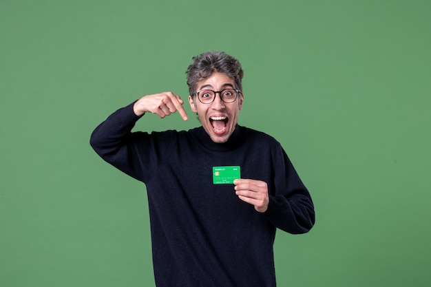 Portrait of genius man holding credit card in studio