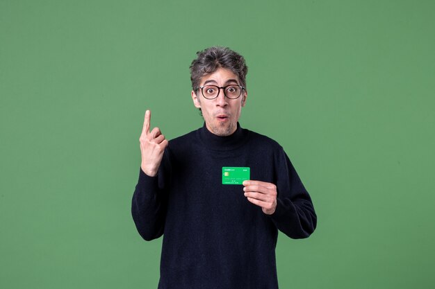 Portrait of genius man holding credit card in studio