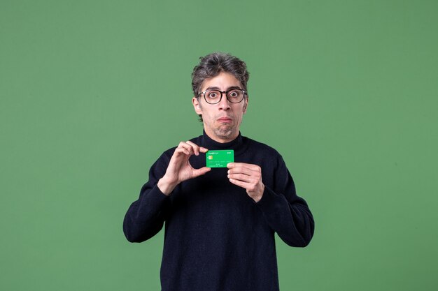 緑の壁に緑のクレジットカードを保持している天才男の肖像画