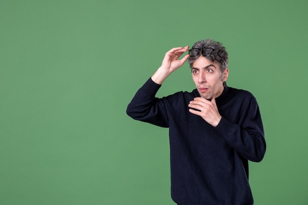 Portrait of genius man in studio shot looking at distance on green wall