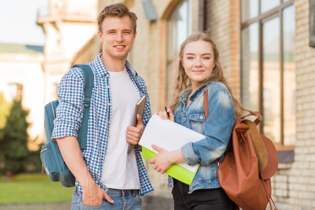 Portrait of girl and boy in front of school