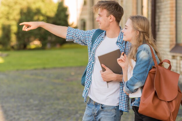 Portrait of girl and boy in front of school