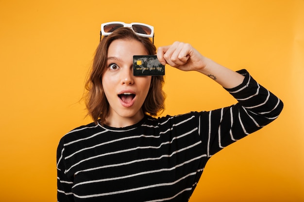 Portrait of a girl holding credit card at her face