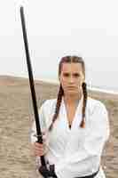 Foto gratuita ritratto di ragazza in costume karate con spada