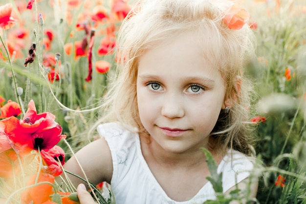 Portrait of a girl among the poppy field