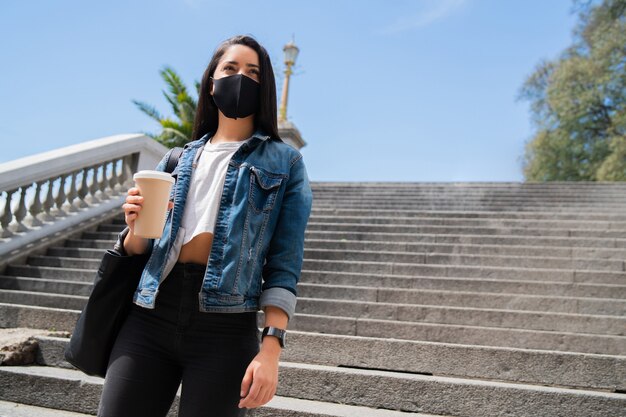 Portrait of a girl wearing a mask holidng a cup