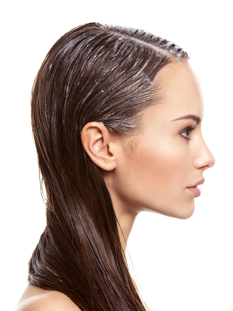 portrait of a girl with applied paint for hairs   on white wall