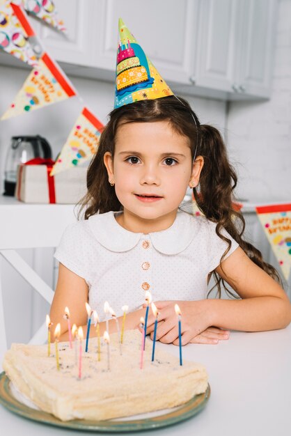 Portrait of a girl with birthday cake on colorful candles