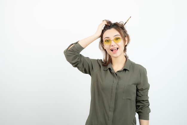 Portrait of girl with messy bun in glasses standing and posing. High quality photo