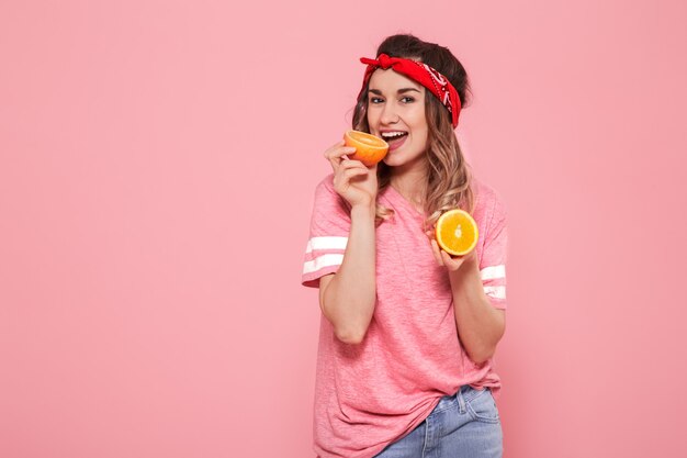 Портрет девушки с апельсинами в руке, на розовом фоне
