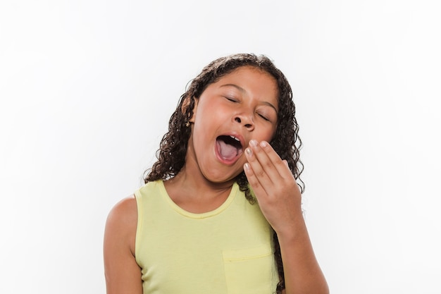 Portrait of a girl yawning on white background