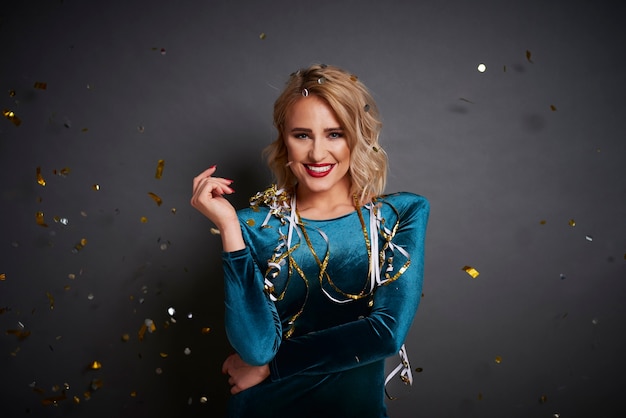 Portrait of glamorous woman under shower of confetti