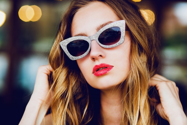 Портрет гламурной стильной блондинки с классными солнцезащитными очками в стиле ретро