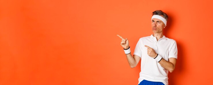 Free Photo portrait of gloomy and disappointed male athlete wearing activewear pointing and looking left with u