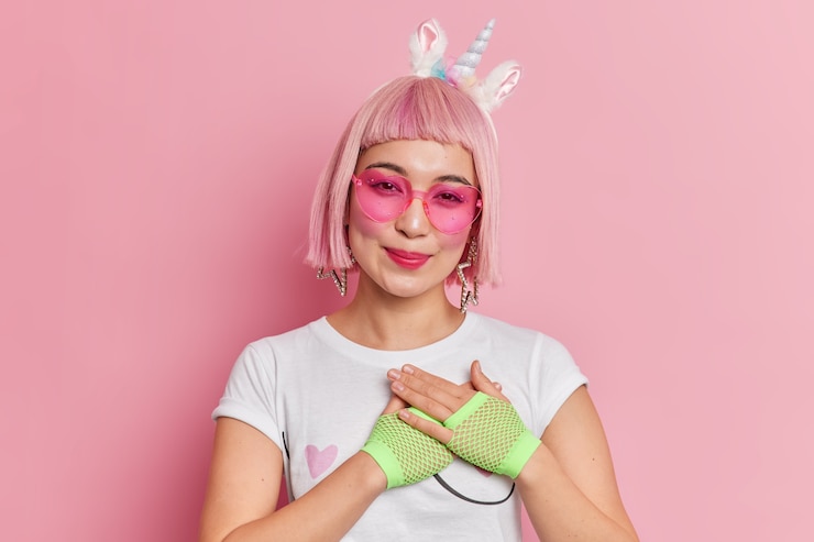 無料Photo トレンディな髪型の格好良いアジアの女性の肖像画は、ユニコーンのヘッドバンドのハート型のサングラスを着用し、tシャツは感謝のジェスチャーをします