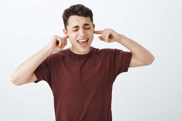 Portrait of good-looking childish caucasian guy in red t-shirt