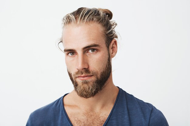 Portrait of good-looking nordic unshaven man with fashionable hairdo posing