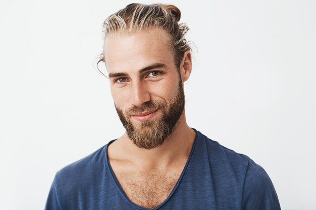 Portrait of good-looking nordic unshaven man with fashionable hairdo posing