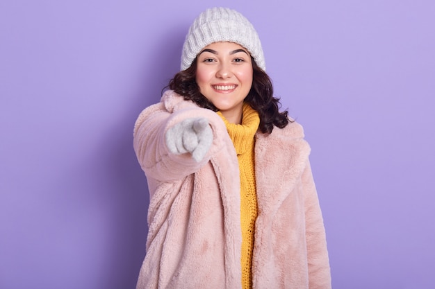 Portrait of good looking positive model reaching out her hand