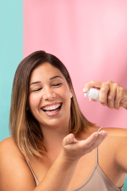 Free photo portrait of a gorgeous woman applying moisturizer