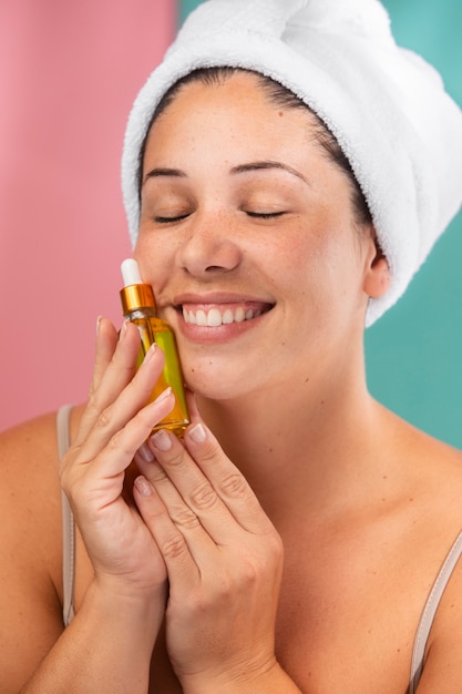 Free photo portrait of a gorgeous woman holding a serum container