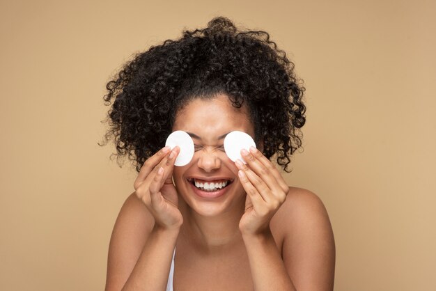 Portrait of a gorgeous woman removing her make-up with pads