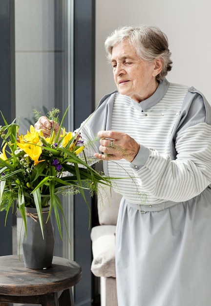 Portrait of grandmother touching flowers