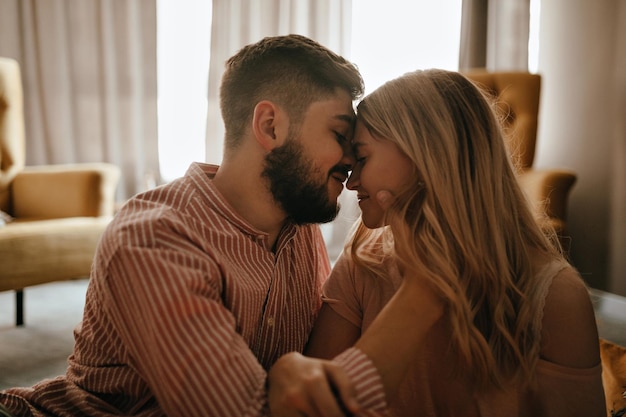 Portrait of guy and his girlfriend in profile touching each other with love and tenderness