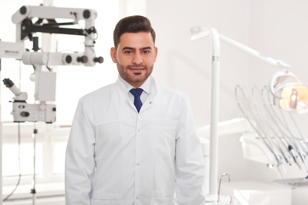 Portrait of a handome male dentist posing at his office
