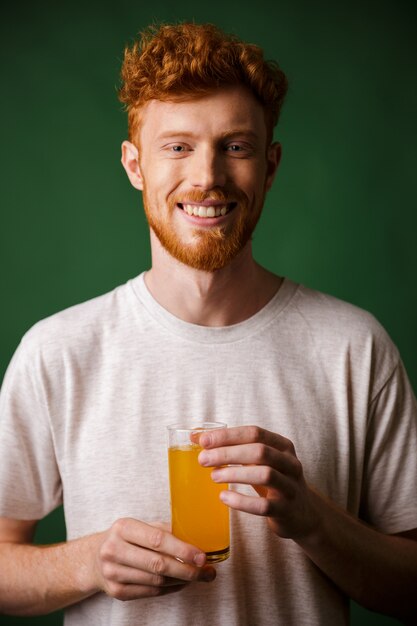 Портрет красивый бородатый мужчина держит стакан апельсинового сока