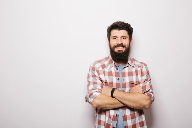 Portrait of a handsome bearded man smiling, isolated over a white wall