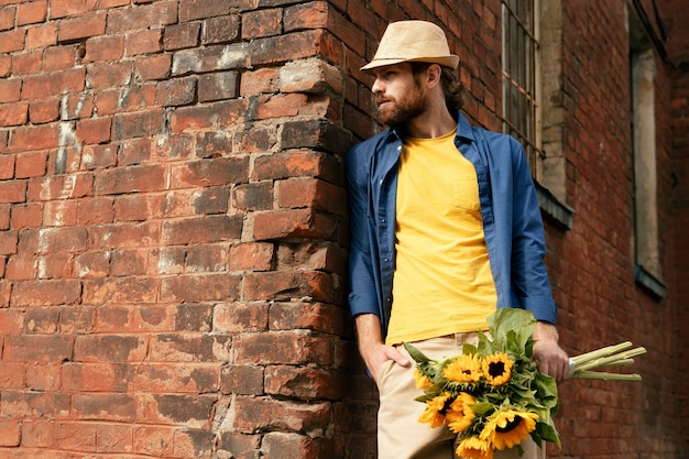 Free photo portrait of handsome bearded man with sunflowers