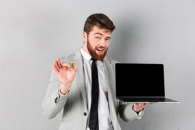 Portrait of a handsome businessman holding bitcoin