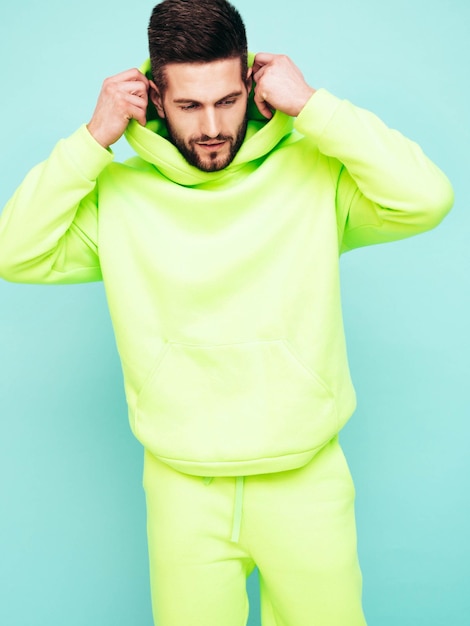portrait of handsome confident model sexy stylish man dressed in yellow hoodie with no logo clothes branding mockup design template for casual sportswear fashion male isolated in studio