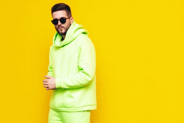 Free photo portrait of handsome confident model sexy stylish man dressed in yellow hoodie with no logo clothes branding mockup design template for casual sportswear fashion male isolated in studio