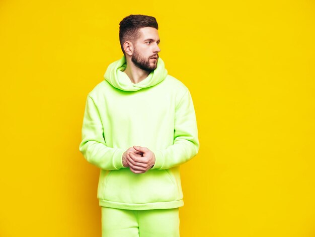 Portrait of handsome confident model Sexy stylish man dressed in yellow hoodie with no logo Clothes branding mockup Design template for casual sportswear Fashion male isolated in studio